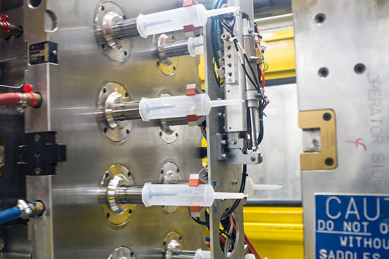 close up of mold machine with plastic tubes coming off